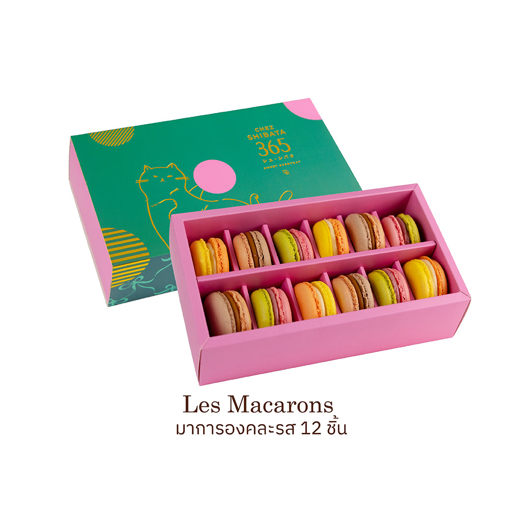 Pink box of colorful macarons with a green lid on a white background