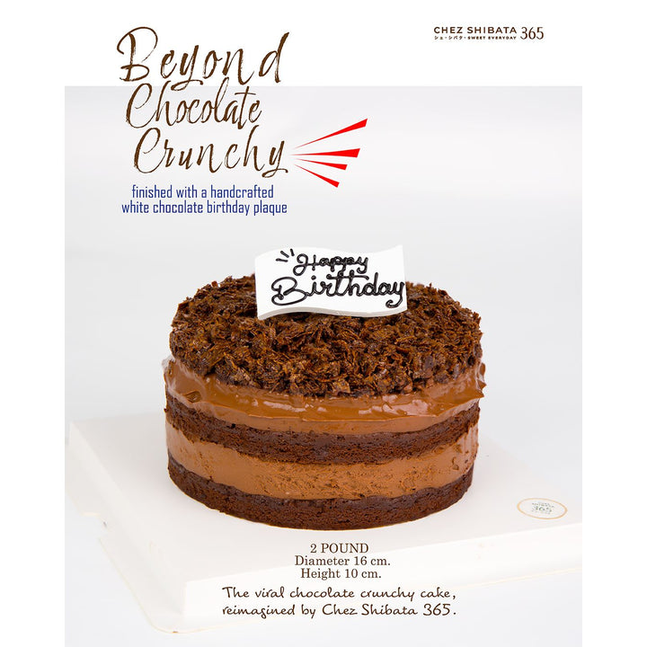 Chocolate birthday cake with a white chocolate birthday plaque on a white background