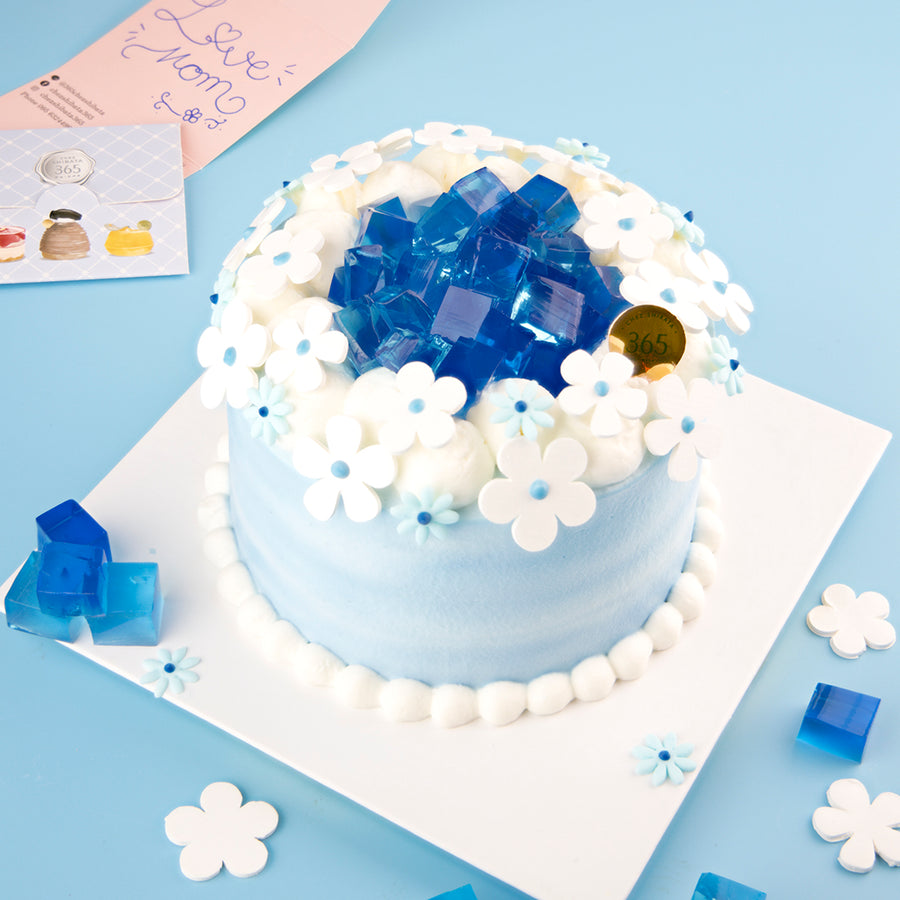 Blue and white cake with decorative elements on a light blue background. Thai mothers day cake. Coconut cake from Chez Shibata365