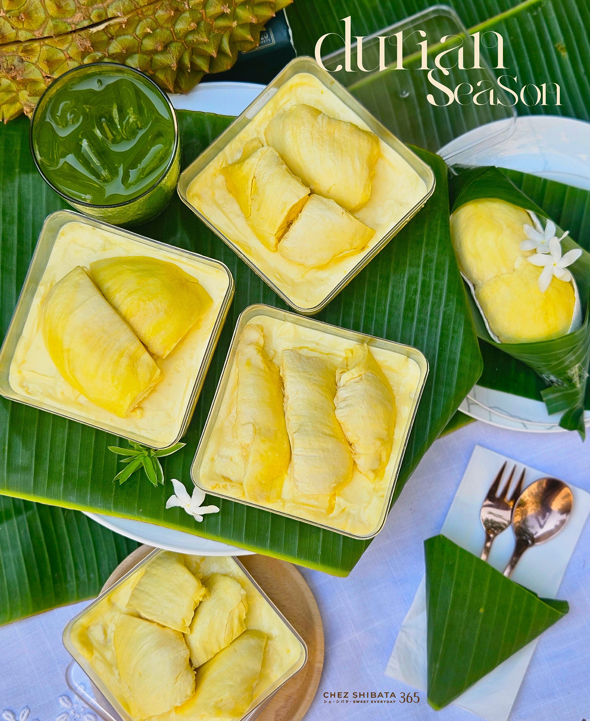Dessert with durian slices served in small containers on a banana leaf, with a glass of green juice and a flower garnish.