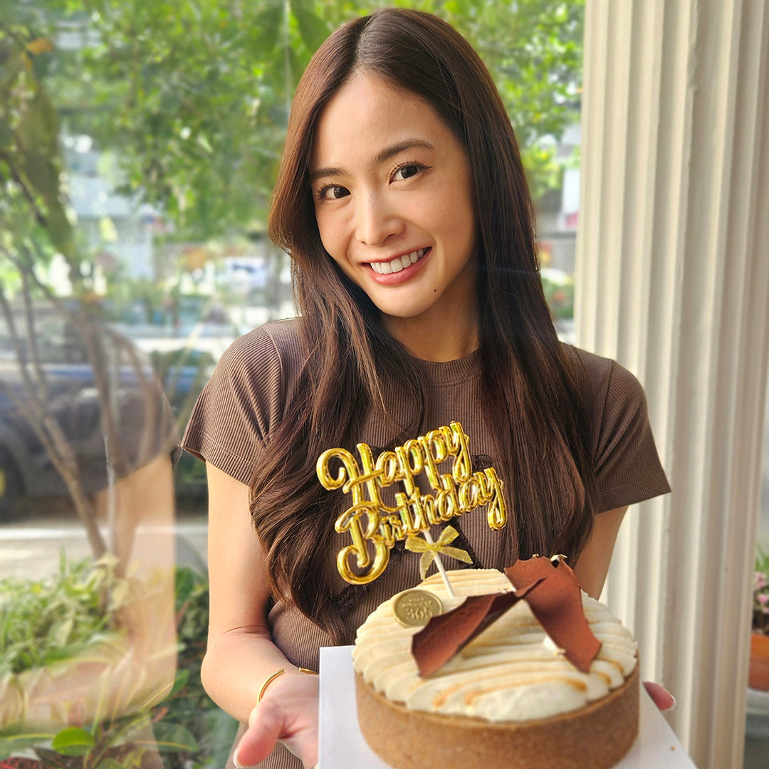 WJMILD holding a birthday cake with 'Happy Birthday' text in a casual setting