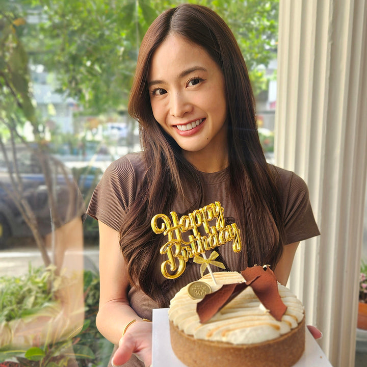 WJMILD holding a birthday cake with 'Happy Birthday' text in a casual setting