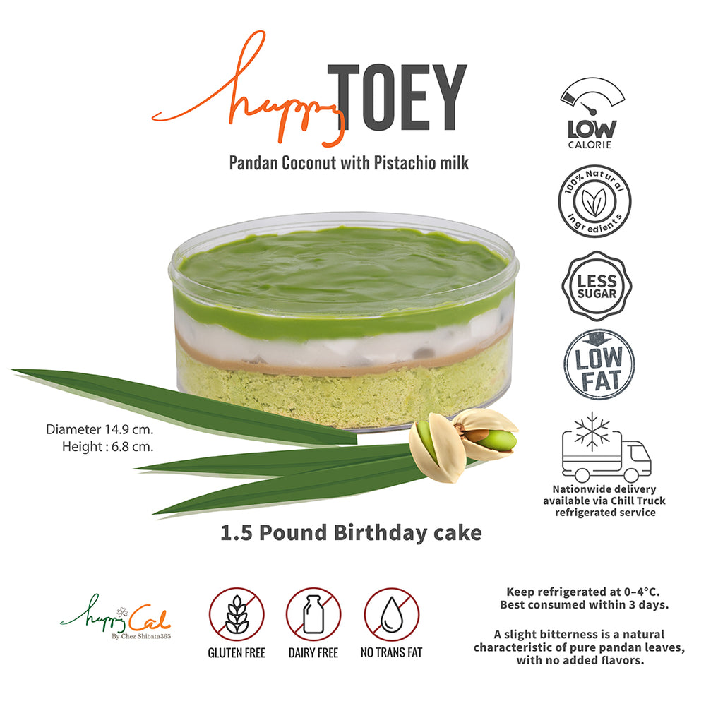 เค้ก Happy Toey รส Pandan Coconut with Pistachio milk ขนาด 1.5 ปอนด์ในกล่องใส ท็อปด้วยชั้นครีมใบเตยเนียนนุ่ม เนื้อเค้กกลูเตนฟรีและนมฟรี ตกแต่งด้วยใบเตยและถั่วพิสตาชิโอ เสิร์ฟพร้อมไอคอนแสดงสัญลักษณ์ Low calorie, Less sugar, Low fat และการจัดส่งแบบ Chill truck ทั่วประเทศ