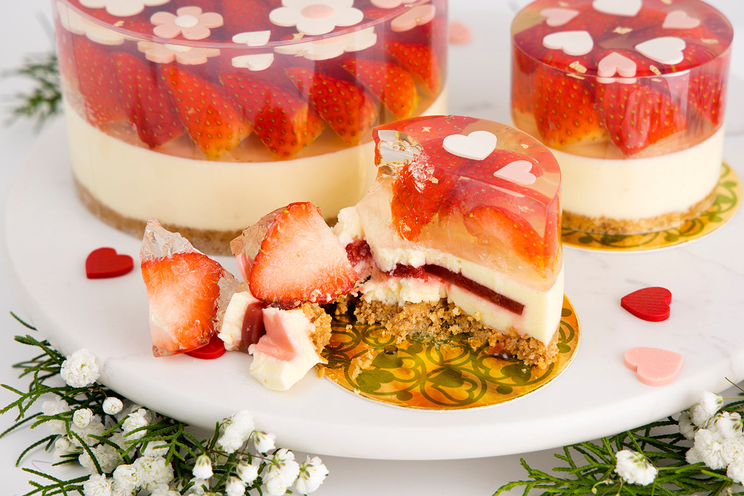 Strawberry-flavored dessert with a slice cut out on a white plate, surrounded by flowers. strawberry cheese cake chez shibata365