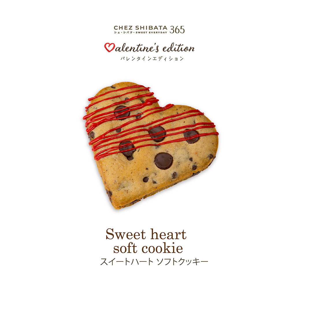 Heart-shaped soft cookie with red drizzle and chocolate chips on a white background, branded &